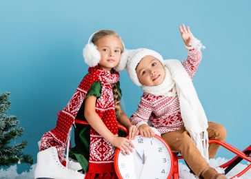 kids-in-winter-outfit-sitting-on-sleigh-near-clock-2023-11-27-05-01-33-utc-1.jpg